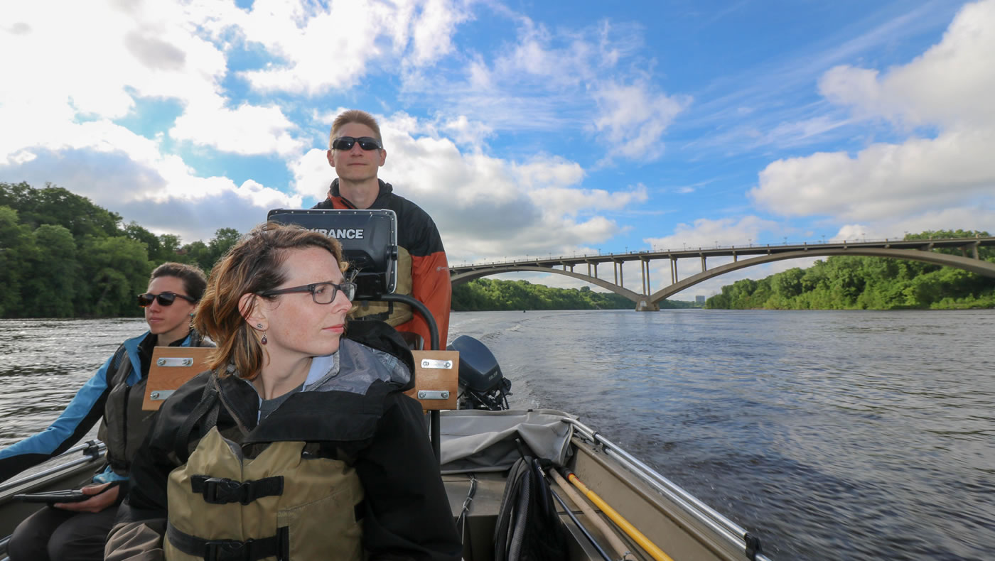 MWMO monitoring team members boating across the Mississippi River to the next sampling site.