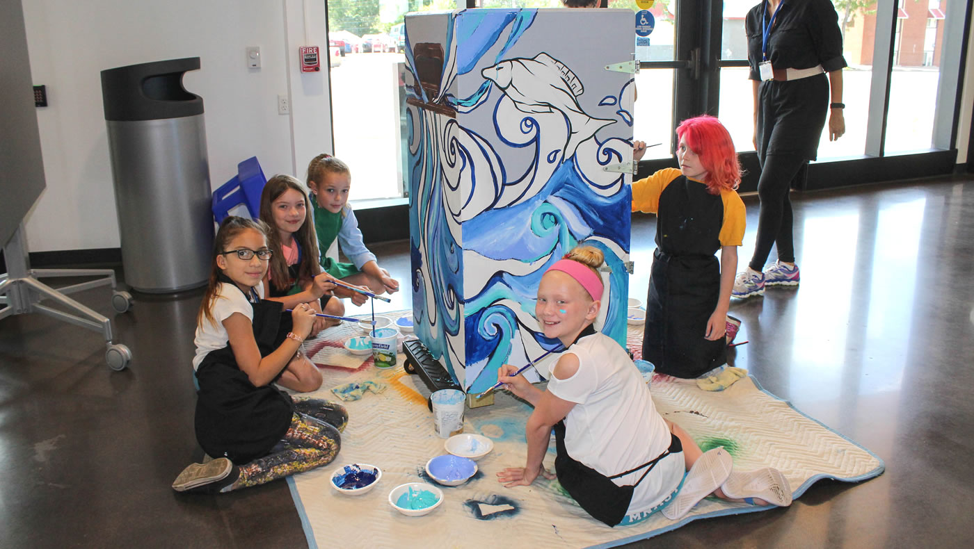 Students painting a watershed trash can mural.