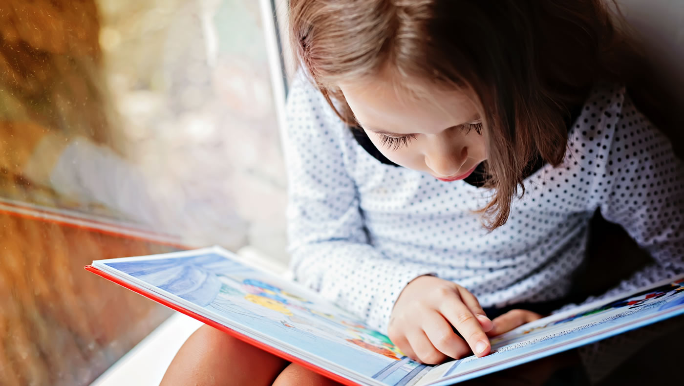 Close-up photo of a girl reading a book. (Shutterstock)