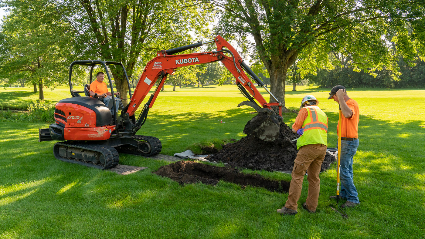 An engineer examines an excavated pit at the Columbia Golf Course.